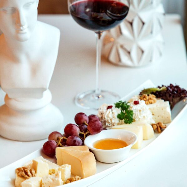 plate with cheeses and a glass of red wine