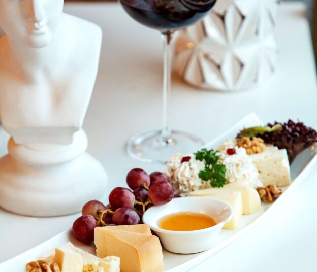 plate with cheeses and a glass of red wine